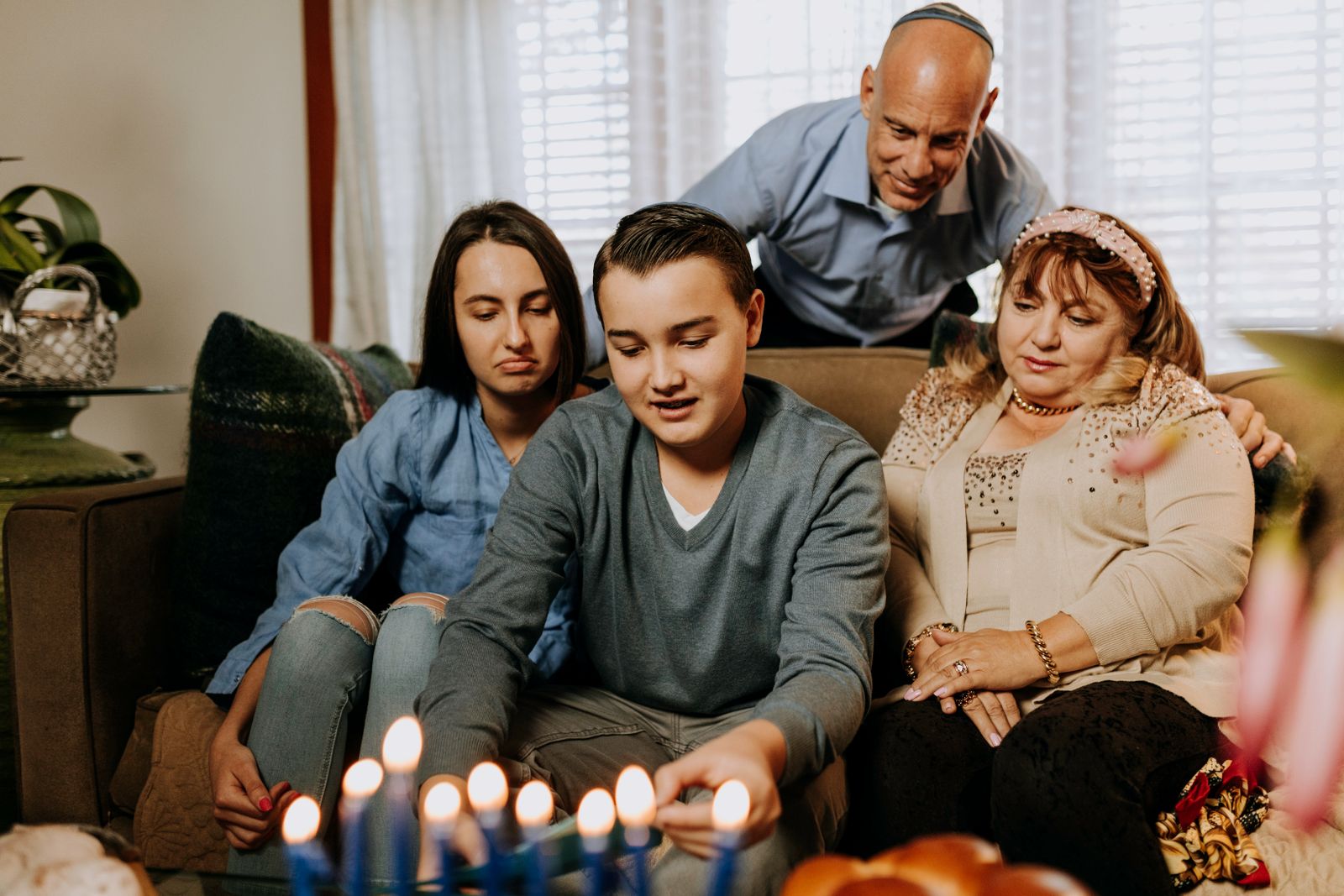 A family gathered around candles at a holiday table